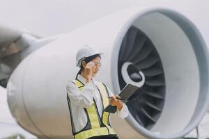 Technician fixing the engine of the airplane,Female aerospace engineering checking aircraft engines,Asian mechanic maintenance inspects plane engine photo
