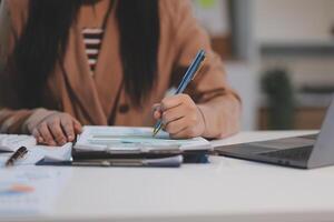 Business woman accountant working audit and calculating expense financial annual financial report balance sheet statement, doing finance making notes on paper checking document. photo