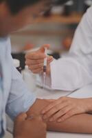 Doctor uses hypodermic needle and syringe to put a dose of medicine as treatment. photo