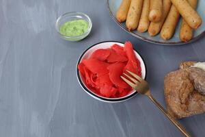 Red ginger in a plate with bread meat on a gray background with space for text. Sandwich recipe. Application of sauces photo