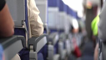 An unfocused view inside the aircraft. The passengers are sitting in their seats. View down the aisle along the seats on the plane video