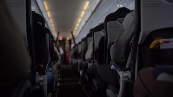 View of aisle pathway on plane with passengers on seats. Unrecognisable passengers sitting in chairs on the plane. can be used for your video