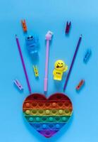 Antistress. Back to school. School supplies on the table. Blue background. Flat lay with copy space. photo