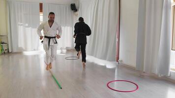 zwei Männer Zug mit Springen Hindernis Übungen während Karate Ausbildung video