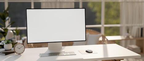 A computer on a table in a contemporary room with sunlight streaming through the large window. photo