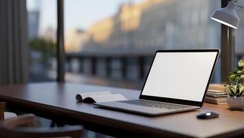 A laptop computer mockup on a wooden desk by the window in a room, illuminated by a table lamp. photo