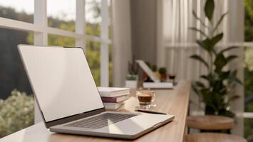 A close-up image of a laptop computer on a wooden table against the window in a minimalist cafe. photo