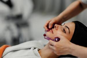 The master gives the client a relaxing facial massage using cold cryo spheres. photo