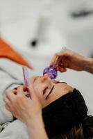 The master gives the client a relaxing facial massage using cold cryo spheres. photo