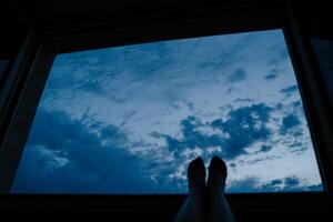 Relaxing View of Cloudy Sky Through Window at Twilight photo