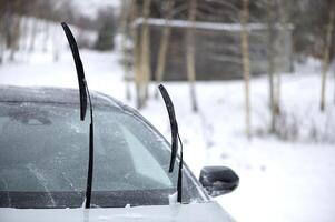 Windshield wiper raised up and icy car windshield. Leave Windshield Wipers Up in the Ice and Snow photo