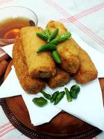 Traditional Indonesian snack Sosis Solo from Central Java, made from savory flour dough and filled with delicious minced chicken or beef then fried. More delicious if eaten with green cayenne pepper photo