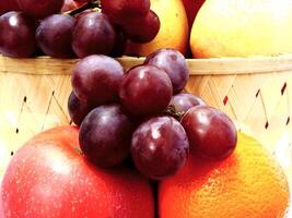mix fruit on wooden basket grape apple pear orange. Harvesting from fruit garden into fruit store photo