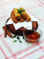 Traditional Indonesian snack Sosis Solo from Central Java, made from savory flour dough and filled with delicious minced chicken or beef then fried. More delicious if eaten with green cayenne pepper photo