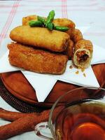 Traditional Indonesian snack Sosis Solo from Central Java, made from savory flour dough and filled with delicious minced chicken or beef then fried. More delicious if eaten with green cayenne pepper photo