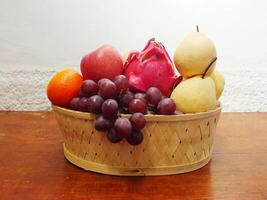 mix fruit on wooden basket grape apple pear orange. Harvesting from fruit garden into fruit store photo