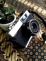 old film camera gear isolated on a traditional Indonesian kain batik patern background. retro photography vintage. nostalgic vacation historical moment photo