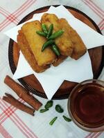Traditional Indonesian snack Sosis Solo from Central Java, made from savory flour dough and filled with delicious minced chicken or beef then fried. More delicious if eaten with green cayenne pepper photo