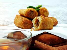 Traditional Indonesian snack Sosis Solo from Central Java, made from savory flour dough and filled with delicious minced chicken or beef then fried. More delicious if eaten with green cayenne pepper photo