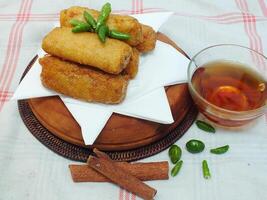 Traditional Indonesian snack Sosis Solo from Central Java, made from savory flour dough and filled with delicious minced chicken or beef then fried. More delicious if eaten with green cayenne pepper photo