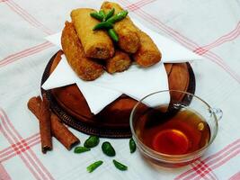 Traditional Indonesian snack Sosis Solo from Central Java, made from savory flour dough and filled with delicious minced chicken or beef then fried. More delicious if eaten with green cayenne pepper photo