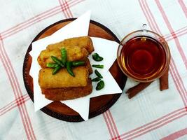 Traditional Indonesian snack Sosis Solo from Central Java, made from savory flour dough and filled with delicious minced chicken or beef then fried. More delicious if eaten with green cayenne pepper photo
