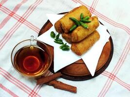 Traditional Indonesian snack Sosis Solo from Central Java, made from savory flour dough and filled with delicious minced chicken or beef then fried. More delicious if eaten with green cayenne pepper photo