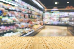 Empty wood table top with supermarket blurred background for product display photo