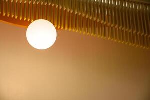 Lamps interior with a brown wall in the modern house style, View of a modern beautiful ceiling light. The minimalist interior is decorated with circular light bulbs in warm tones 2024. photo