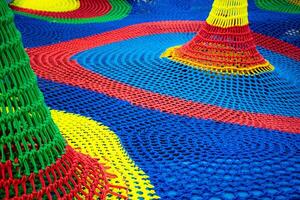 Close up colorful rope net labyrinth for children at playground, Details of texture colorful braided ropes in various shapes in the indoor playground. photo
