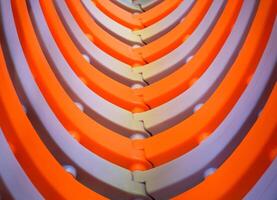 Orange and White Plastic Children's Play Tunnel in Indoor Playground, Curved colorful plastic molding in abstract background. photo