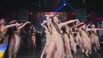 Group of dancers performing on stage with colorful lights in the background. video