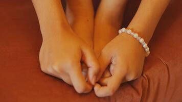 Close-up of hands forming a heart shape on a warm-toned background, with a focus on connection and love. video