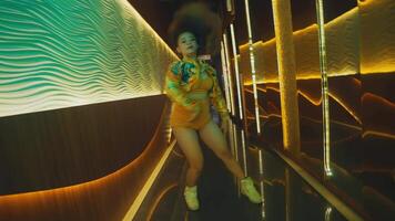 Blurred motion of a woman walking through a neon-lit corridor, creating a dynamic and colorful urban night scene. video