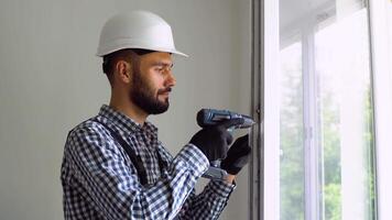Turkish workman in uniform installing or adjusting plastic windows in the living room at home video