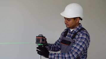 Indian man adjusting laser level tool. Laser leveler device video