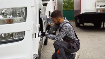 Professional mechanic using socket wrench while changing truck tire on car service video