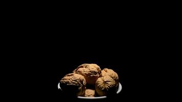 Walnuts in a bowl in rotation on black background video