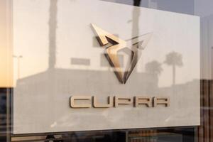 Torrevieja, Spain - 09-07-2024, Cupra logo, highlighted by golden hues of a setting sun. Ideal for automotive branding, marketing materials, and editorial content on modern car brands. photo