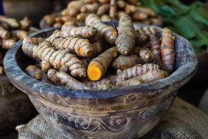 Fresh turmeric root displayed in a wooden bowl at the market photo