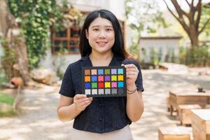 Model holding colors checker board, Colour accuracy marker tile, Colors chart for calibrate accurate colors grading in Photography and Cinematography photo