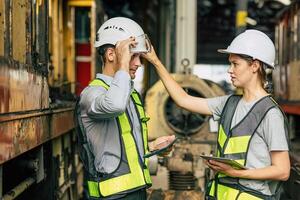 Safety engineer supervisor female officer blame young new worker for not properly firm and safe wearing helmet head protection equipment when working in factory danger area. photo