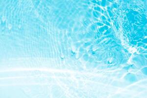 Bluewater waves on the surface ripples blurred. Defocus blurred transparent blue colored clear calm water surface texture with splash and bubbles. Water waves with shining pattern texture background. photo