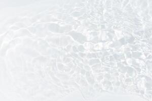 Blue water with ripples on the surface. Defocus blurred transparent blue colored clear calm water surface texture with splashes and bubbles. Water waves with shining pattern texture background. photo