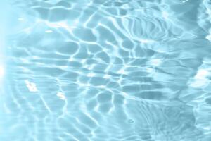 Bluewater waves on the surface ripples blurred. Defocus blurred transparent blue colored clear calm water surface texture with splash and bubbles. Water waves with shining pattern texture background. photo