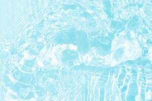 Blue water with ripples on the surface. Defocus blurred transparent blue colored clear calm water surface texture with splashes and bubbles. Water waves with shining pattern texture background. photo