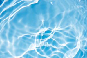 Bluewater waves on the surface ripples blurred. Defocus blurred transparent blue colored clear calm water surface texture with splash and bubbles. Water waves with shining pattern texture background. photo