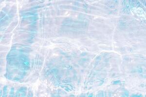 Bluewater waves on the surface ripples blurred. Defocus blurred transparent blue colored clear calm water surface texture with splash and bubbles. Water waves with shining pattern texture background. photo