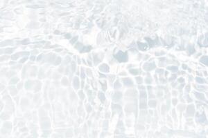 Blue water with ripples on the surface. Defocus blurred transparent blue colored clear calm water surface texture with splashes and bubbles. Water waves with shining pattern texture background. photo