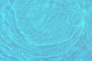 Bluewater waves on the surface ripples blurred. Defocus blurred transparent blue colored clear calm water surface texture with splash and bubbles. Water waves with shining pattern texture background. photo